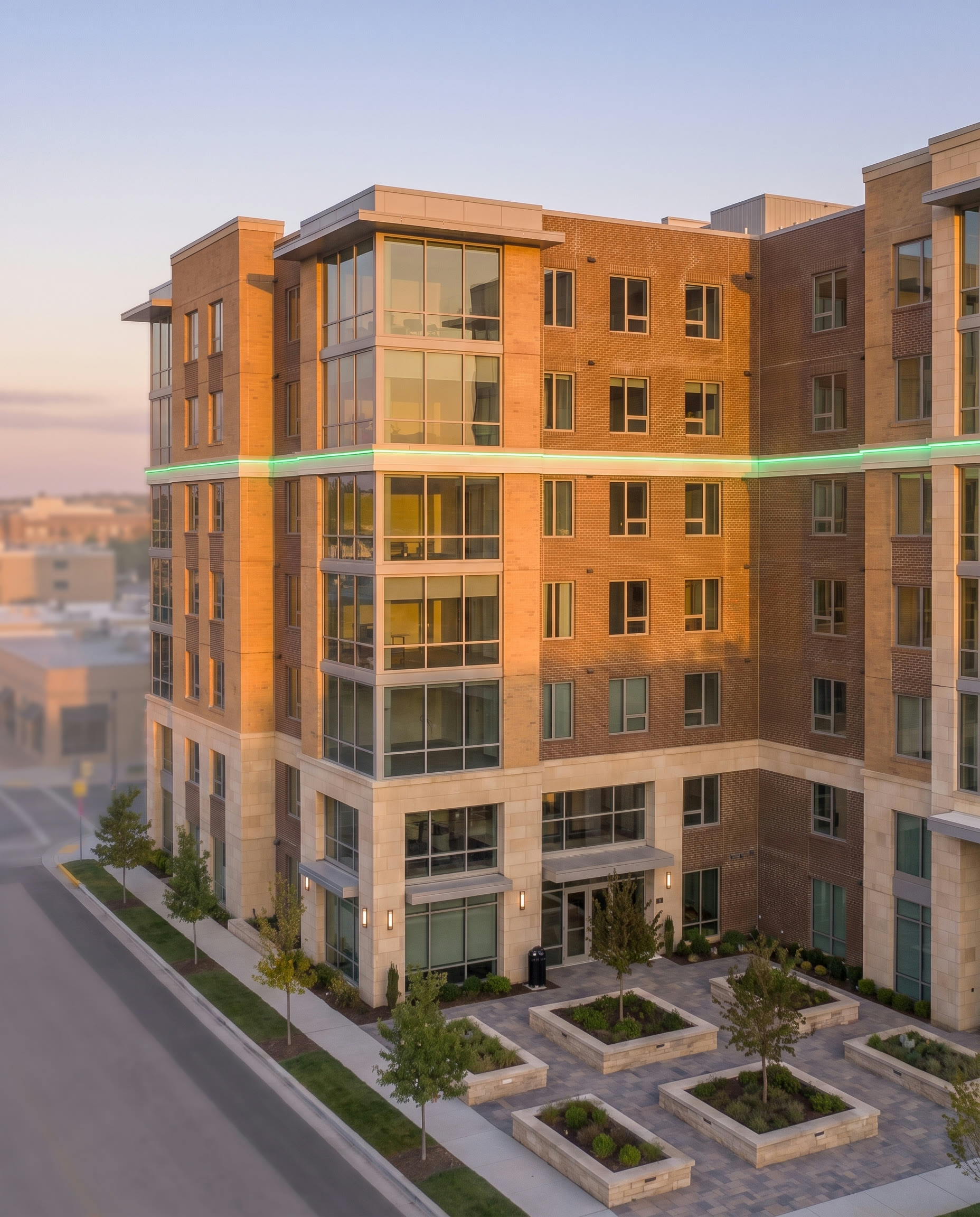 Dark commercial building over still water with a green light band